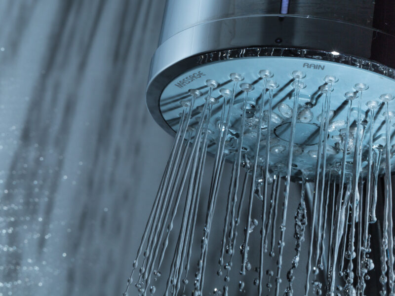 Shower,Head,With,Water,Stream,On,Grey,Background